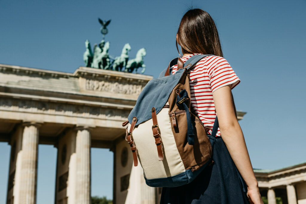 a tourist or a student with a backpack near the brandenburg gate in berlin in germany.